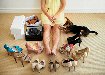 她不能决定她的鞋袜 被割成一副女人坐在家里的鞋子包围着的样子图片
