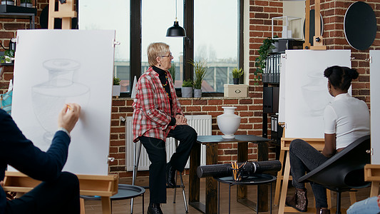年长妇女向艺术班的人解释艺术美观;背景图片