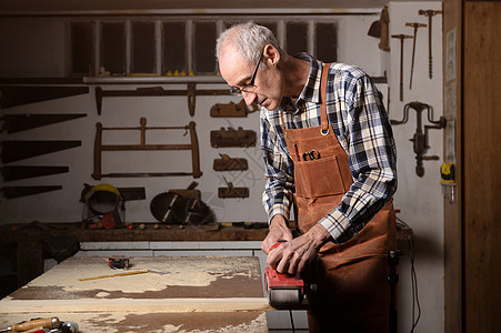 在木板项目或木工木工车间 木匠用带式砂光机打磨木材电气男人桌子男性灰尘木头工匠标志工具力量图片