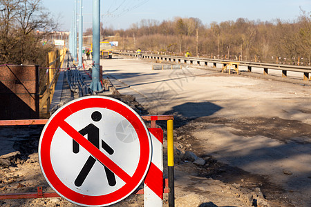 屏阻人行道和有禁止行人通行的跨出男子图象的标志的路障图片