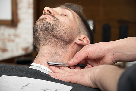 理发师用剃刀刮胡子的男子工作高清图片素材