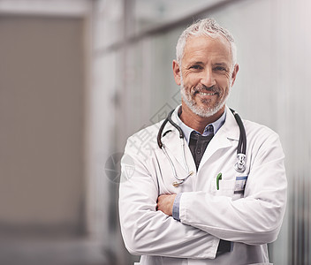 让我来帮你照顾你的总体健康 一位成熟的男医生站在医院的肖像 他是个大男子主义医生背景图片