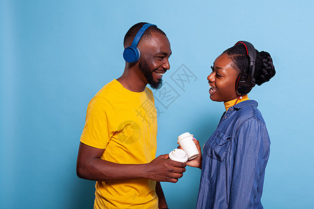 男人和女人笑着听耳机上的歌声图片