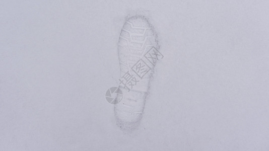 一个人在雪地上的脚印 鞋子踩在新雪上 刚下的第一场雪是一个人在冬天迈出的第一步 雪的白色质地带有浅浅的印记背景图片
