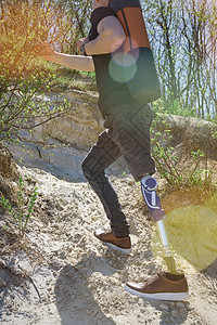 穿黑色牛仔裤和T恤衫 随身带垫子的男子在山上旅行冒险男人技术动机截肢活动假肢男性膝盖截肢者图片