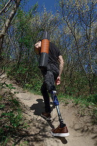 穿黑色牛仔裤和T恤衫 随身带垫子的男子在山上旅行截肢者膝盖截肢活动冒险假肢动机技术男人男性图片