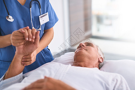 一名成熟的男性病人躺在医院床上 而他的手却被医生抓着 (笑声) 我们正与你同在图片
