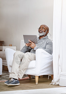 这让我想起了过去的美好时光 一个英俊的老人在家中沙发上休息时 使用数码平板电脑拍到的镜头成人裁剪胡须长椅药片思维退休房间老年男性图片