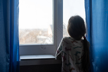 孩子的萧条 可怜的小女孩孤单地坐在窗边 在家里抱着她自己 复制太空空间图片