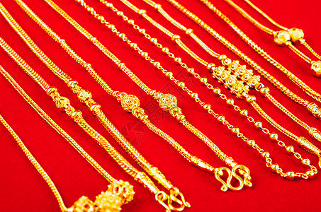 红色天鹅绒布上的金项链礼物财经皮革女人味财富戒指宝石衣领奢华吊坠图片