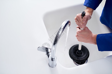 保持下水道清洁 水管工的裁剪镜头 用柱塞疏通排水管图片