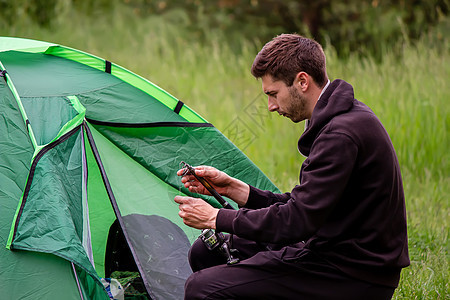一个人坐在旅游帐篷附近 自然 娱乐 露营男人活动闲暇游客冒险自由成人旅行远足日落图片
