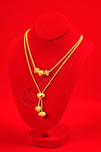 领带展台与金项链 在红色天鹅绒布上配饰金融奢华金属礼物宝石戒指魅力个人支架背景图片