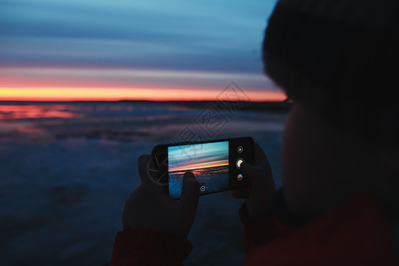 渐变色背景男人用手机拍下海上日落天空的照片 渐变色 天空纹理 作为背景的美好的抽象自然日落背景