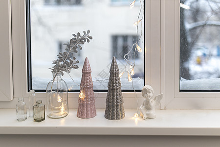 灰色和粉红色陶瓷圣诞树 一个装有人造银枝的玻璃瓶 加兰在圣诞节把窗台上装饰玻璃瓶子花瓶新年房子塑像阴影精神云杉风格背景图片
