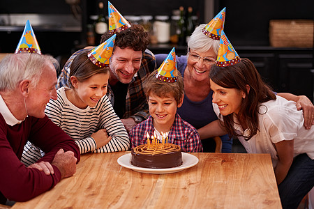 许个愿 趁你还没吹灭他们之前 拍到一个快乐的小男孩和家人一起庆祝生日图片