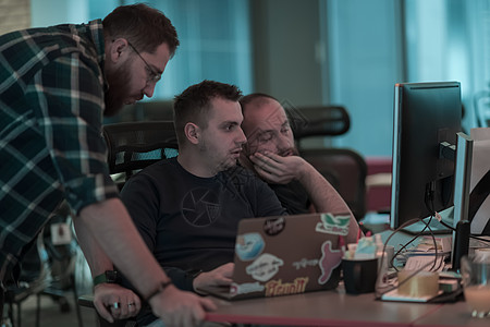 三个男人坐在现代办公室时 专注地盯着电脑看的照片 有选择的焦点企业服务空间眼镜商业自由职业者工作用户手机技术图片