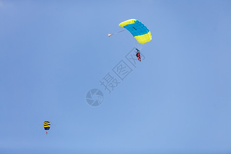 Skydiver 背景上有一小块降落伞的树冠 蓝色天空 近距离特写 在降落伞下Skydiver吊索潜水空气活动天篷飞行员保险运动图片