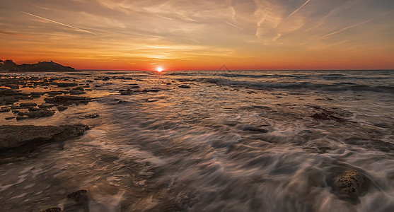 日出在海面上闪耀 运动模糊的波浪图片