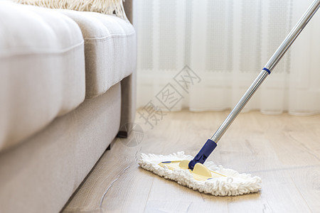 沙发附近有白色拖把的清洁地板长椅洗涤剂家政家务抛光工作刷子清洁工家庭服务图片
