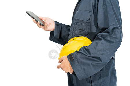 站在蓝色覆盖层的工人手持硬帽并使用智能手机制造业工作男性头盔职业塑料安全帽手臂帽子工作室图片