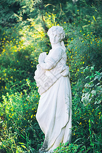 绿色自然背景下年轻女性的白大理石雕塑图片