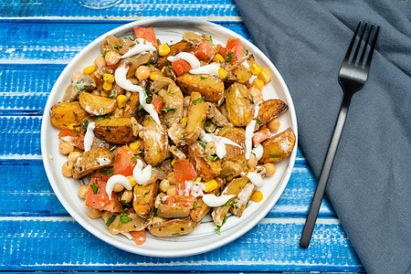 美味的马铃薯 鸡皮豆 番茄和蘑菇沙拉 在蓝生菜桌上的碗里配有煎饼和香肠 健康 自制 素食食品图片