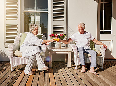 一位快乐的老夫妇在家里院子里喝着果汁烤面包呢 (注 一种美酒)图片