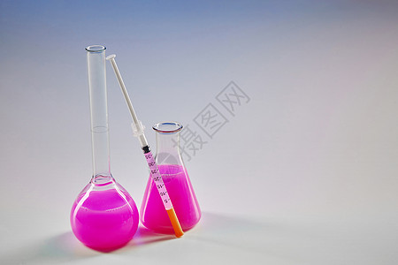 两瓶配有粉红化学试剂的药瓶和在白色上隔离的试验包 Corona病毒实验室研究 COVID-19大流行体图片