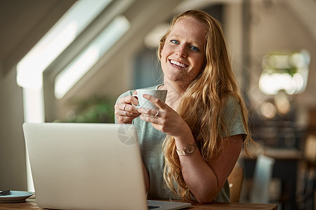 使用免费 wifi 完成博客会更好 一名年轻女子在咖啡店使用她的笔记本电脑的镜头图片