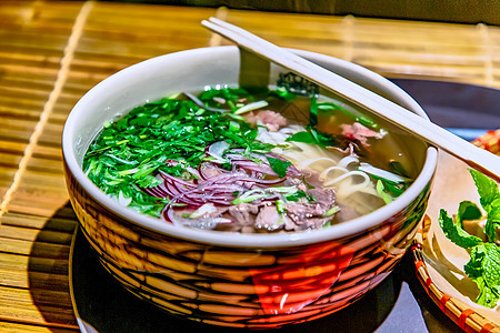 传统的越南汤 Pho Bo在一个大碗里面条绿色午餐草本植物食物辣椒盘子蔬菜烹饪肉汤图片