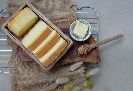 卡通面包与盒子四块黄油蛋糕的切片 在木箱里配有黄油和蜂蜜蛋糕糕点烹饪养分盒子营养作品糖果食物食品背景