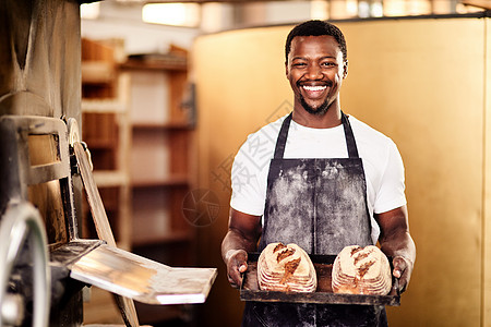 如果你想要新鲜的 那就来我的面包店吧 一位男面包师在他的面包店里拿着新鲜出炉的面包的镜头图片
