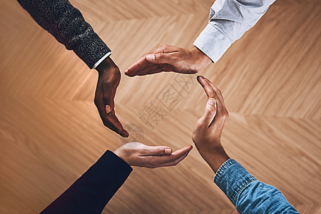 只有团结一致 我们才会强大 一群身份不明的商务人士用手围成一个圆圈的高角度拍摄图片