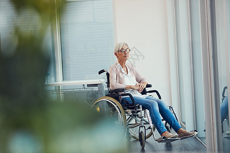 谁知落得如此下场 一位老年妇女在养老院坐在轮椅上时看起来若有所思的全长镜头图片