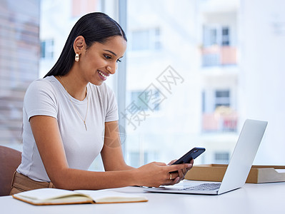 沟通在任何企业中都很重要 一位迷人的年轻女商务人士坐在办公室的办公桌前发送短信的镜头图片