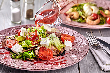 希腊健康混合沙拉在粉红色盘子上配有银叉 包括红绿叶 微绿色 青菜 洋葱 番茄和切片牛肉服务草药早餐胡椒叶子萝卜美食午餐食物蔬菜图片