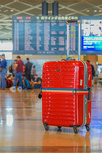 放在机场的红色手提箱背景图片