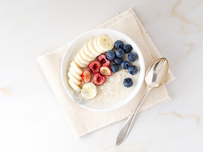 大碗美味和健康的燕麦粥 有水果和果汁 早餐 早饭的咖哩 顶端风景 白大理石桌图片