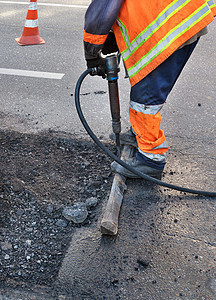 道路工人在修路时 用大锤清除一些沥青油图片