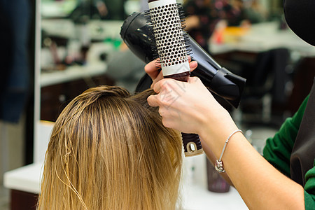 用吹毛机和圆梳子干头发 理发程序享受造型师成人刷子工作理发师女性美容顾客美容师图片