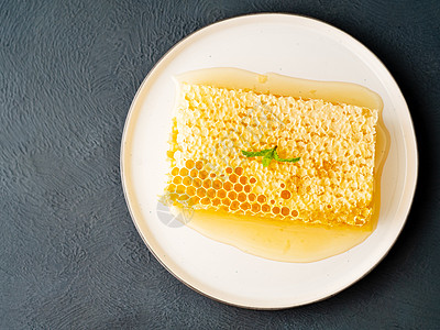 蜂巢中的蜂蜜 特写 在白色陶瓷板上 在木制质朴的桌子上 侧视图 阳光水果香料营养陶瓷花粉荒野甜点液体食物草本植物图片
