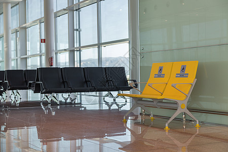 国际机场为残疾人预留的空优先座位 登机前等候区的普通和黄色残疾人座位图片