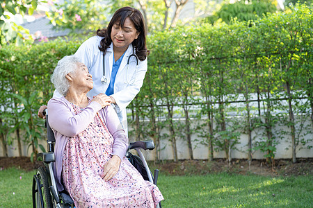 医生帮助和照顾坐在护理医院病房公园轮椅上的亚洲老年或老年老妇人患者 健康强大的医疗理念海报护士医院护理失智全景椅子玫瑰病人女士图片