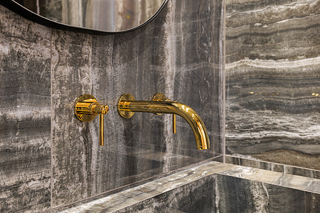 在洗手间浴盆中用大理石墙砖的现代金水龙头贴近时光图片