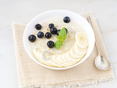 大碗美味健康的燕麦片 包括水果和浆果 早餐 早餐 侧视图 白色大理石桌子图片