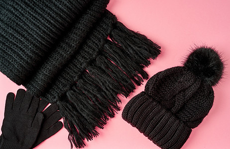 平整地躺着冬天或秋天温暖的女伴  黑织围巾 帽子配饰毛皮季节黑色手套粉色优雅材料针织衣服图片
