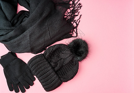 平整地躺着冬天或秋天温暖的女伴  黑织围巾 帽子配饰衣服粉色季节毛皮黑色优雅针织手套材料图片