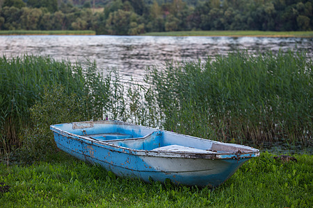 河边草地上的老渔船图片