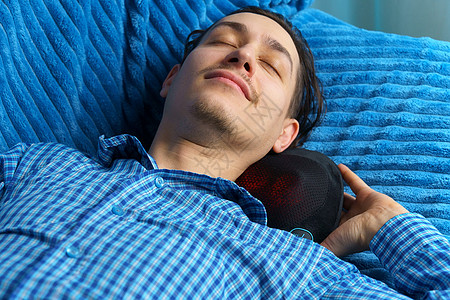 男人按摩的颈部紧贴着一个按摩枕头 身体感到更放松图片